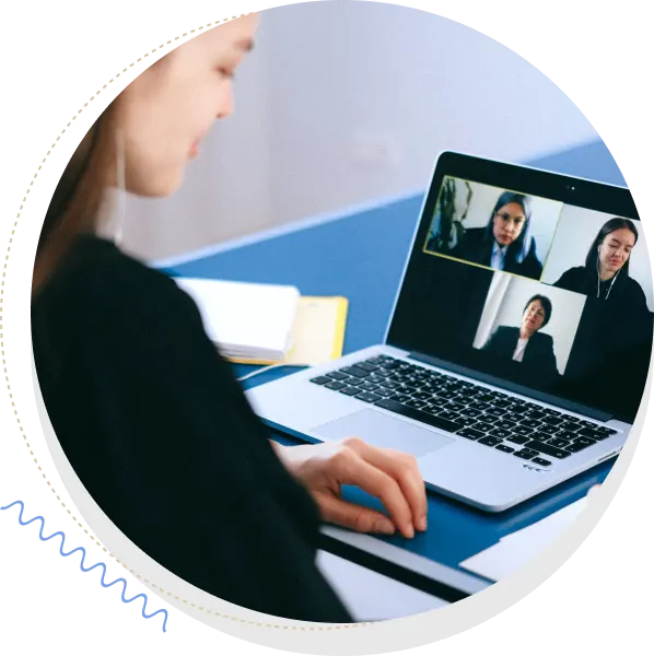 An image of a woman sitting in front of a laptop attending a zoom meeting.