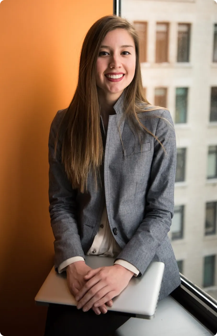 A picture of a trusted real estate agent sitting near the window of a commercial building.