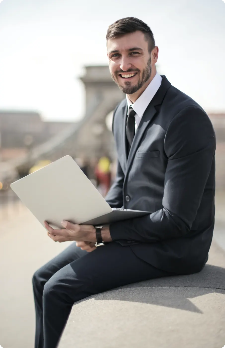 An image of an smiling professional man sitting with a laptop.